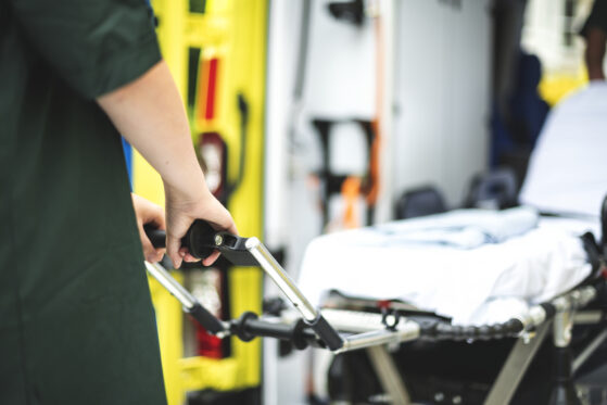 Close-up of arm removing stretcher from back of ambulance